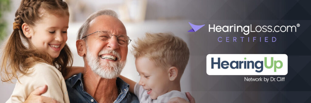 A smiling senior man is embraced by a girl and a boy, alongside logos for HearingLoss.com and HearingUp.