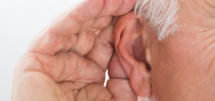Close-up of a person cupping their hand behind their ear to better hear a sound.