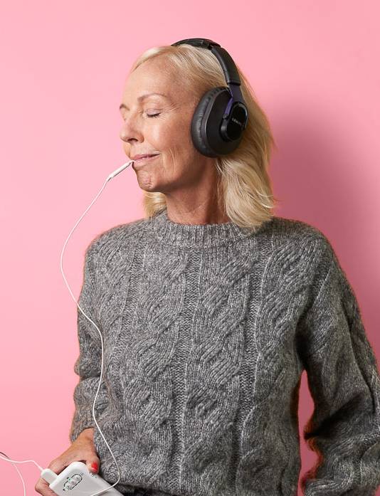 An older woman uses Lenire while relaxing with her eyes closed